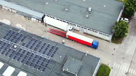 Trucks-with-semi-trailers-stand-on-the-parking-lot-of-the-logistics-park-with-loading-hub-and-wait-for-load-and-unload-goods-at-warehouse-ramps-at-sunset