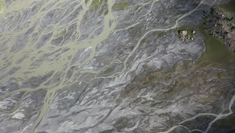 Cinematic-drone-shot-waterways-in-the-mountains-at-Naltar-Valley-in-Pakistan,-downward-angle-aerial-shot