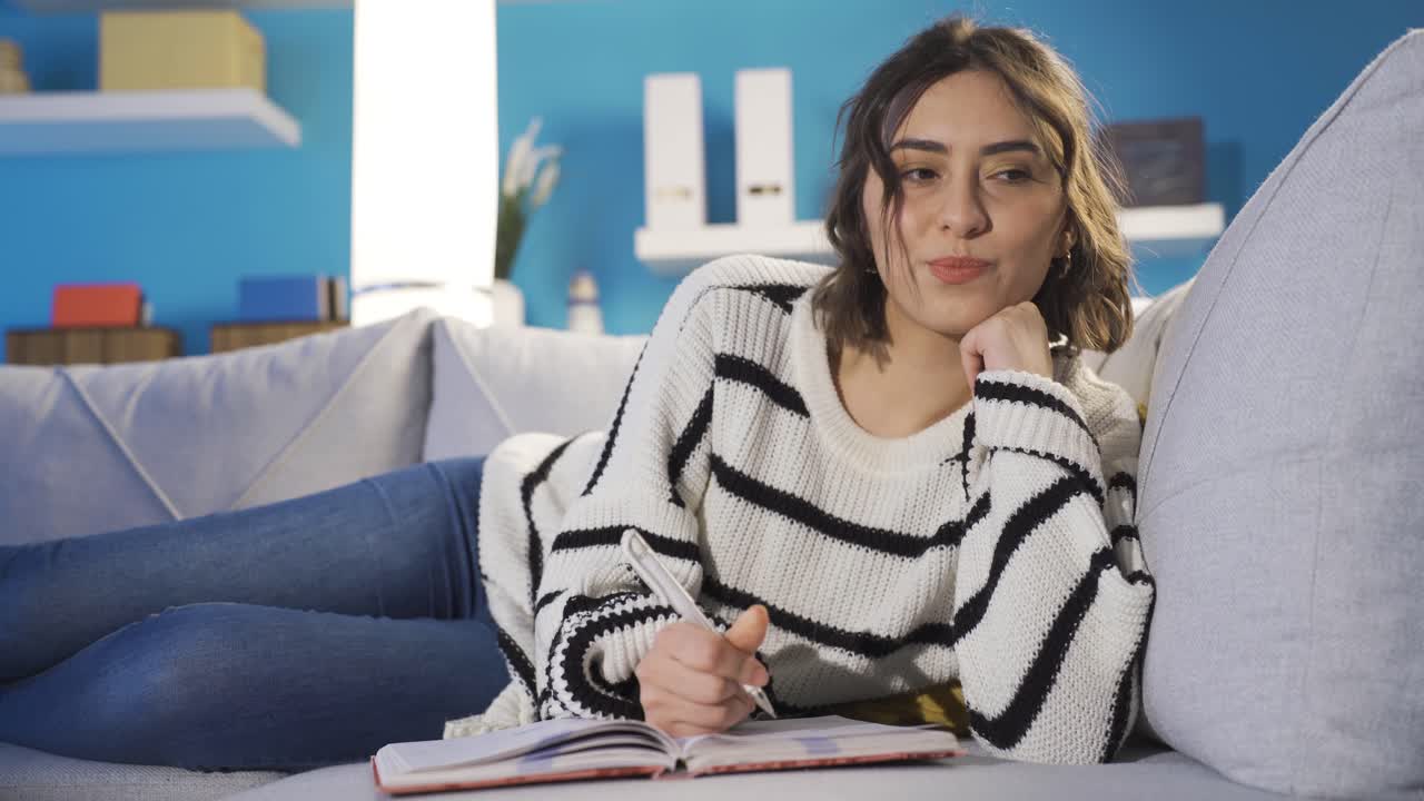 una mujer tomando notas de sus recuerdos. libro de recuerdos.