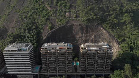 Langsame-Annäherung-Aus-Der-Luft-Von-Wohnhochhaus-Eigentumswohnungen,-Die-In-Der-Teilweise-Ausgeschnittenen-Bergseite-Wohnen