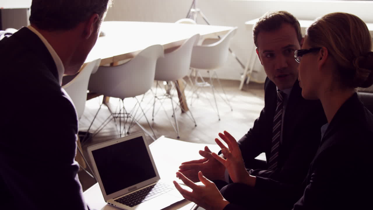 personas de negocios serios trabajando juntos mientras miran el portátil