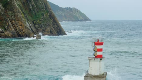 port-side marker or alignment lighthouse marks entrance to rocky haven, faro de puntas, maritime view from pasajes san juan, sea perspective