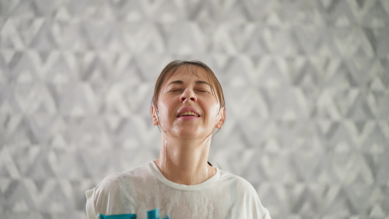 Wet woman runs on treadmill closeup. Satisfied lady athlete with bottle of water in hands finishes endurance exercise. Exhausted from leg exercises