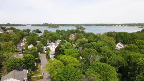 aerial footage of coastal community at hingham ma, showing trees in full summer foliage, drone jib down