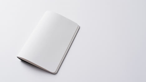 primer plano de un libro en blanco abierto con espacio de copia en un fondo blanco en cámara lenta