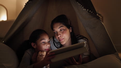 mother and daughter enjoy story time in a tent