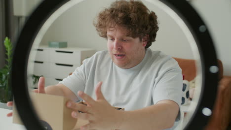 blogger unboxing shirt and talking to camera as filming clothing review