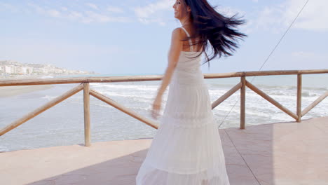 Dama-Juguetona-Vestida-De-Blanco-Disfrutando-En-El-Camino-De-La-Playa