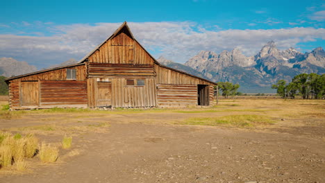 historic wooden barn with grand teton mountains in background