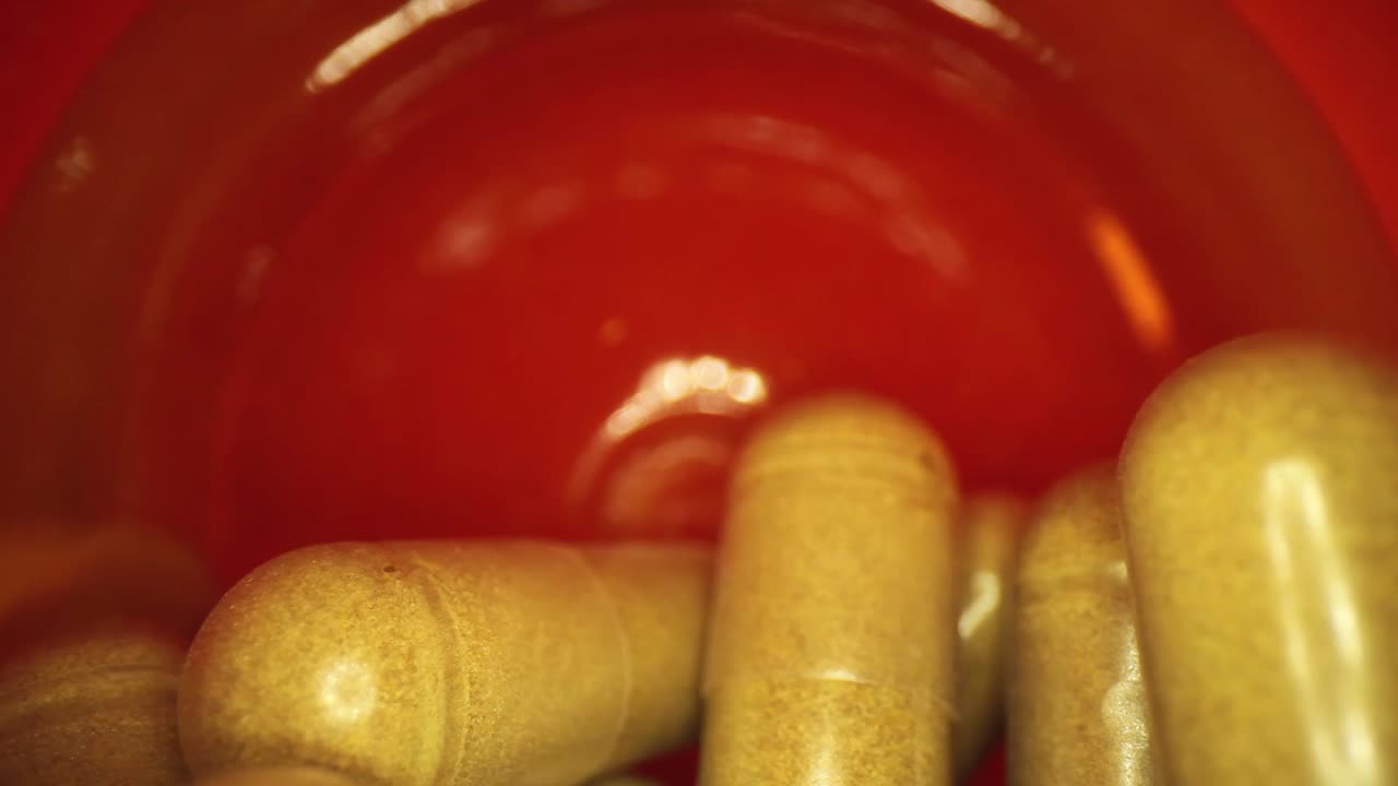 주황색 보충제 약병 바닥에서 반쯤 빼낸 다음 다시 밀어 넣습니다.