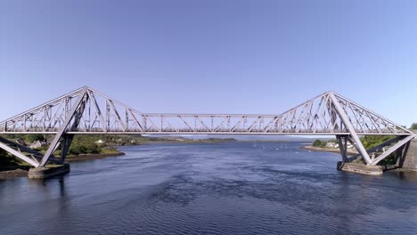 Low-pull-back-aerial-shot-heading-east-up-Loch-Etive,-revealing-the-Connel-Bridge-at-high-tide