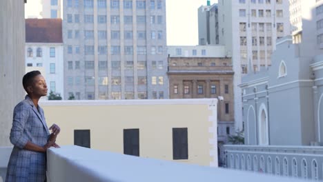 Businesswoman-standing-in-balcony-at-office-4k