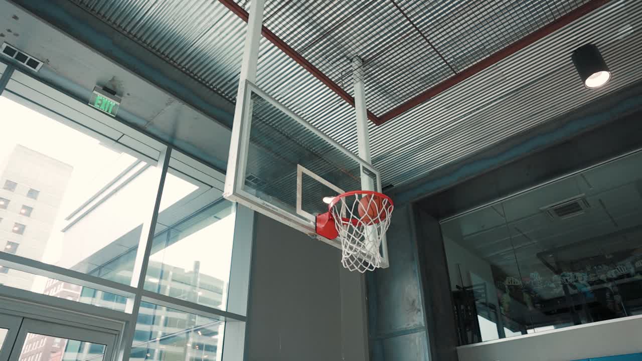 Slow motion footage of a basketball swishing through an indoor hoop