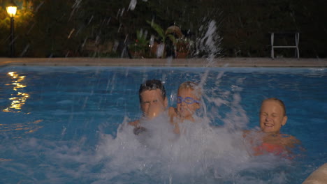 familia feliz salpicando agua en la piscina