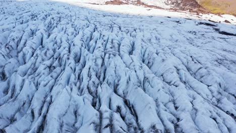 aerial view of icy glacier in iceland, jagged split surface