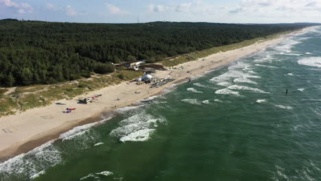 Antena:-Toma-Giratoria-De-Surfistas-Montando-Olas-Con-Cometas-En-Un-Día-Soleado