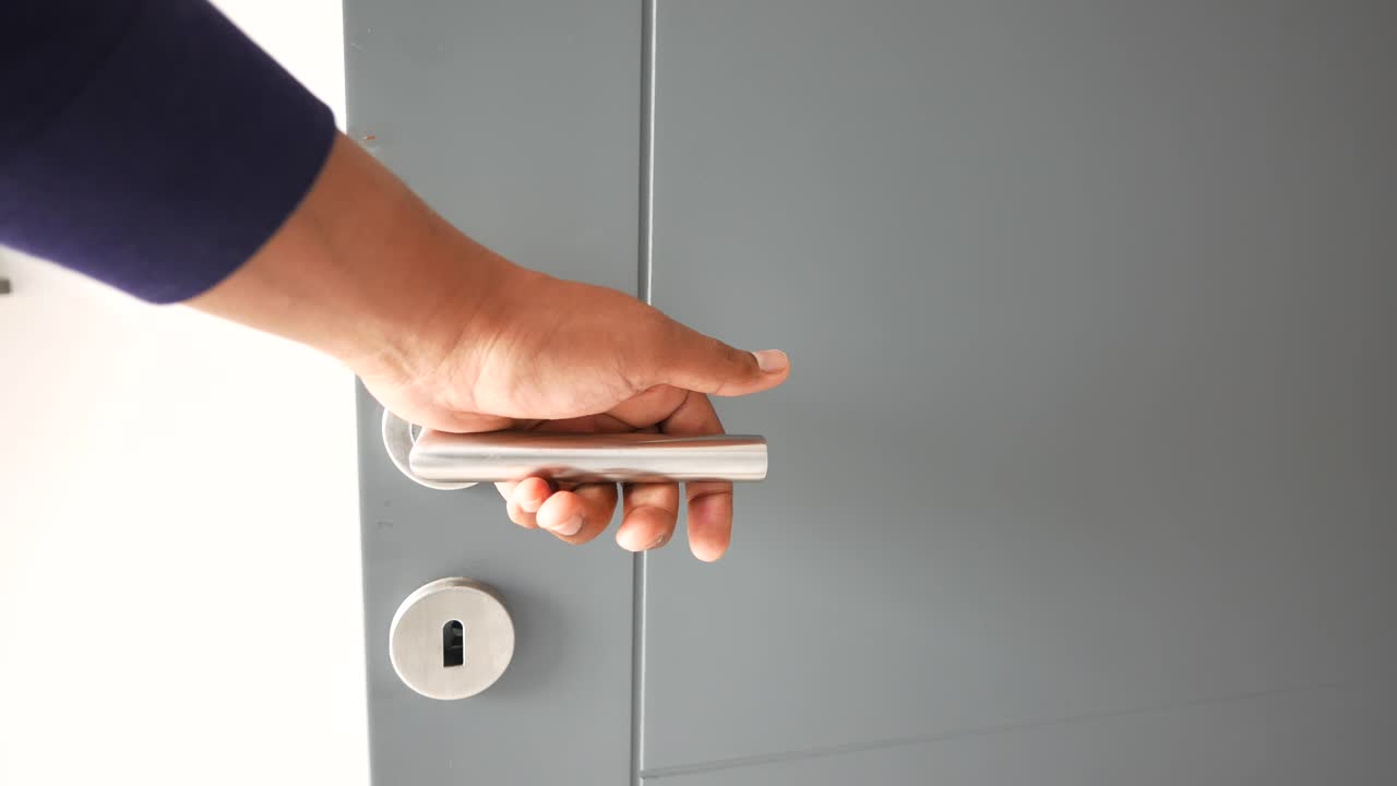 회색 문을 열고 있는 사람