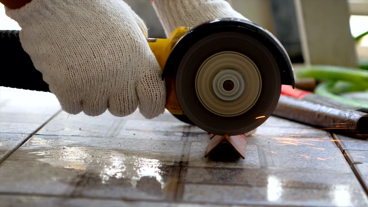 manos de mecánico usando molienda eléctrica para cortar el acero con el parpadeo de la luz del fuego
