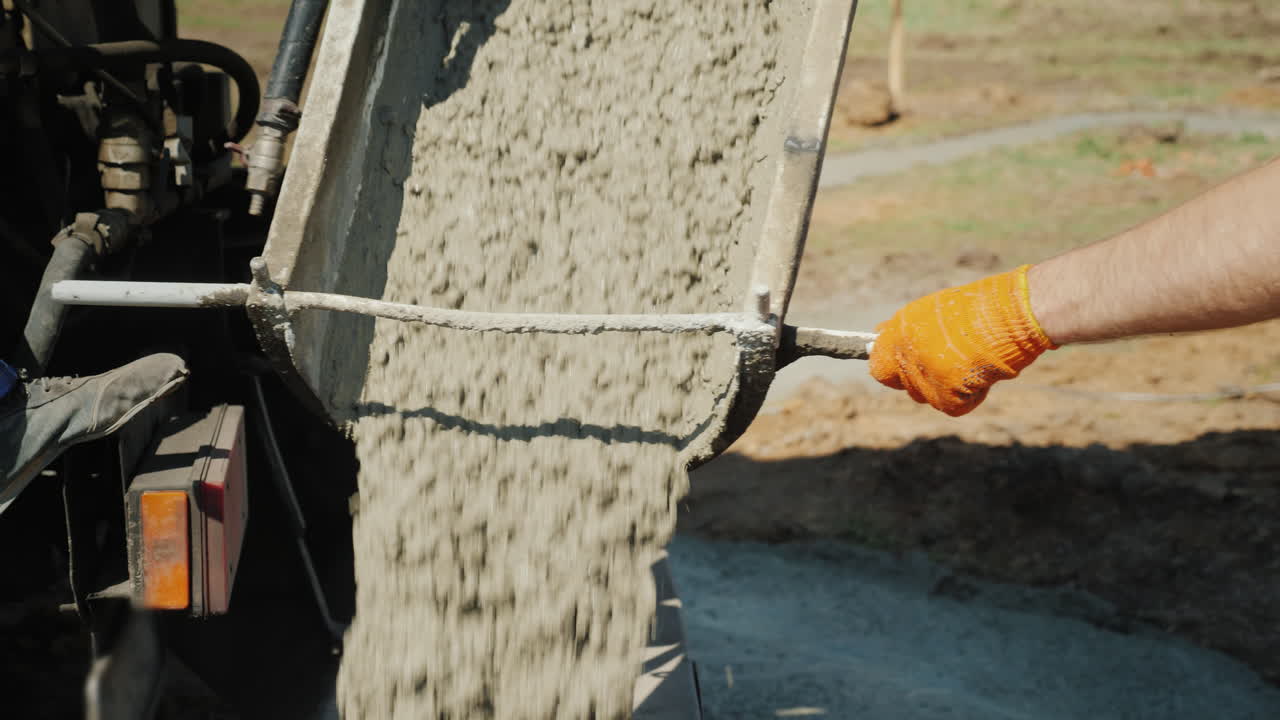 작업자가 콘크리트가 흐르는 낙하산을 지시하는 기초를 붓는 작업