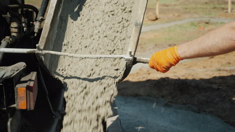 Trabajar-En-Verter-La-Base,-El-Trabajador-Dirige-El-Conducto-Desde-El-Cual-Fluye-El-Concreto