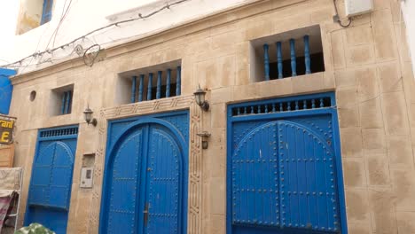 view of the traditional blue door and restaurant in essaouira, medina, morocco