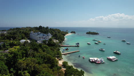 Luftaufnahmen-Rückwärts-Fliegen-Auf-Einer-Karibischen-Insel-Mit-Einem-Dock-Und-Booten,-Cayo-Levantado,-Dominikanische-Republik