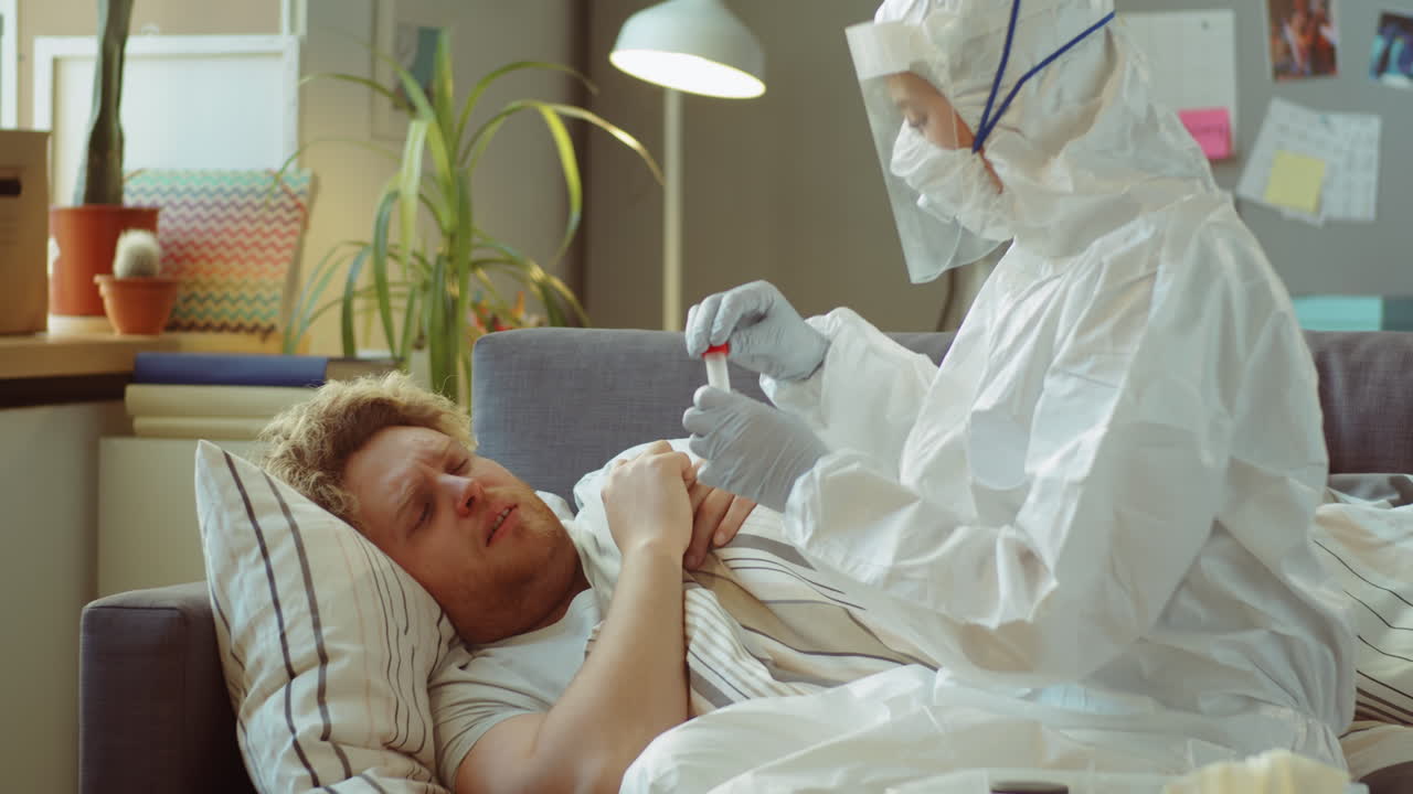 больной человек получает тест на ковид-19 от врача дома