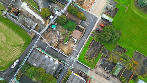 aerial footage approaches a large industrial chemical plant in the uk, revealing pipelines, metal structures, cooling towers, and chemical storage