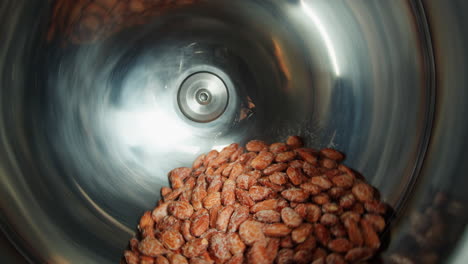 almond processing in a rotating metal bowl