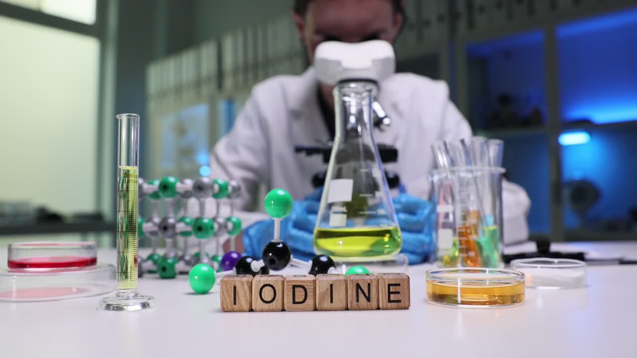 Scientist conducting chemical research with lab equipment and 'Iodine' inscription