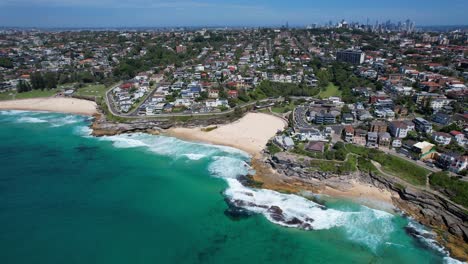 panoramic view over bronte beach and tamarama beach coastline in sydney, australia - drone shot