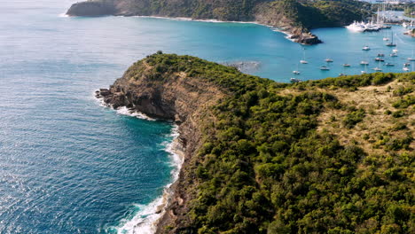 sunny aerial shot of english harbor in antigua, caribbean with views of yachts, sailboats, marina, bay and cliffs