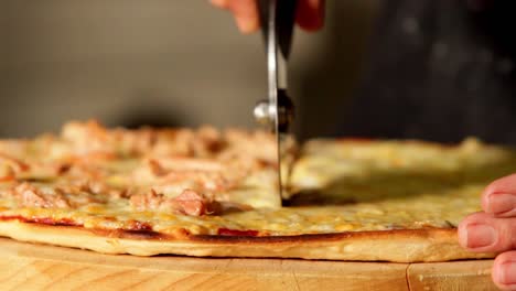 close up, hands using a pizza cutter, pizza slices