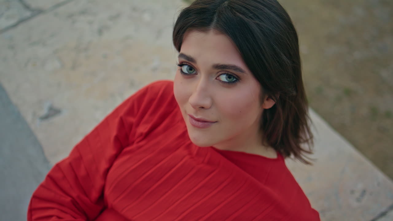 Brunette model looking camera leaning fountain at city portrait. Woman posing