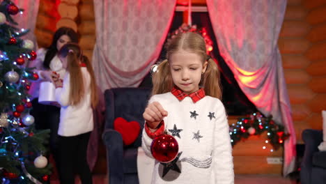 attractive child with christmas tree toy. pretty girl hanging christmas toy.