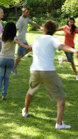 group of casual young friends playing ring a ring a rosie