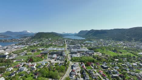 moa and spjelkavik with brusdal lake in background - backward moving summer aerial establishing shot above road e39