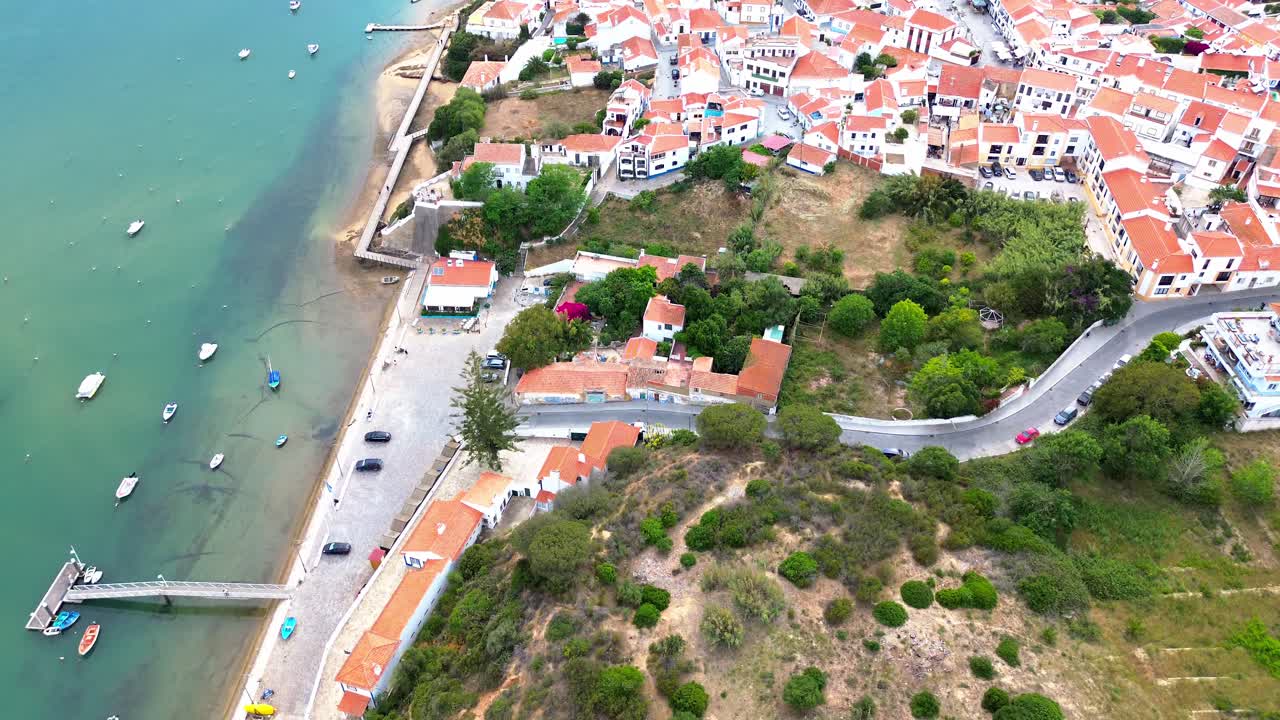 vista aerea su una piccola città costiera, oceano blu, tetti rossi, 4k