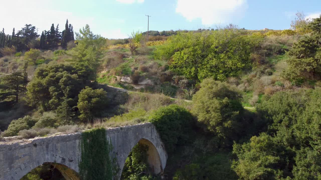 antiguo acueducto de piedra en creta: vista aérea de una estructura histórica que se extiende por un verde valle