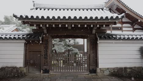 Snowflakes-falling-in-slow-motion-in-front-of-temple-gate-in-Arashiyama,-Kyoto