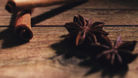 camera pulling focus - close shot of cinnamon with star anise on a wooden table