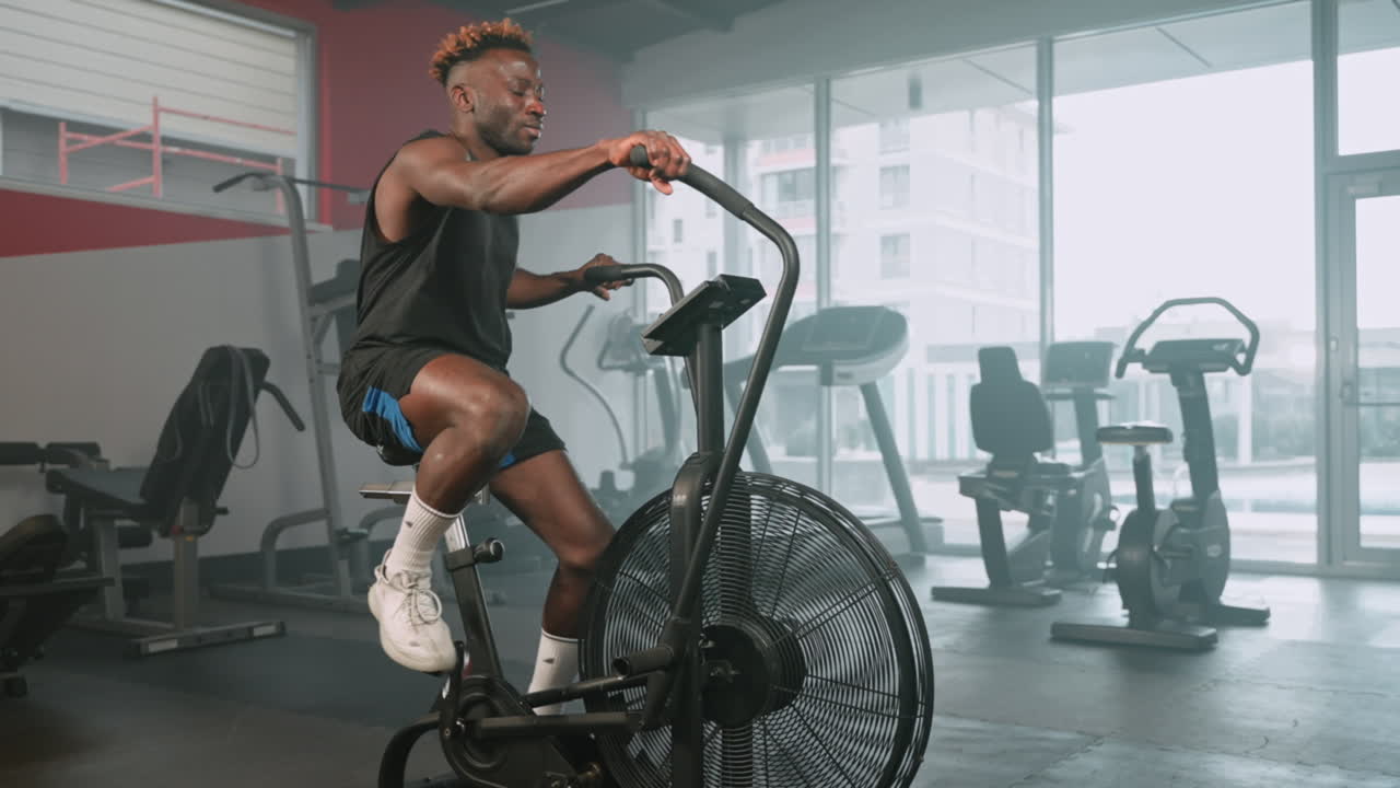 체육관 에서 공기 자전거 를 타고 운동 하는 사람