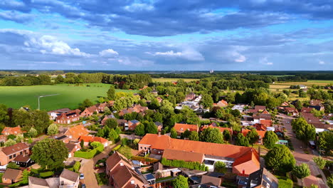 green sunny scenery of a beautiful town in the netherlands. heavy fluffy clouds in the sky above. aerial view