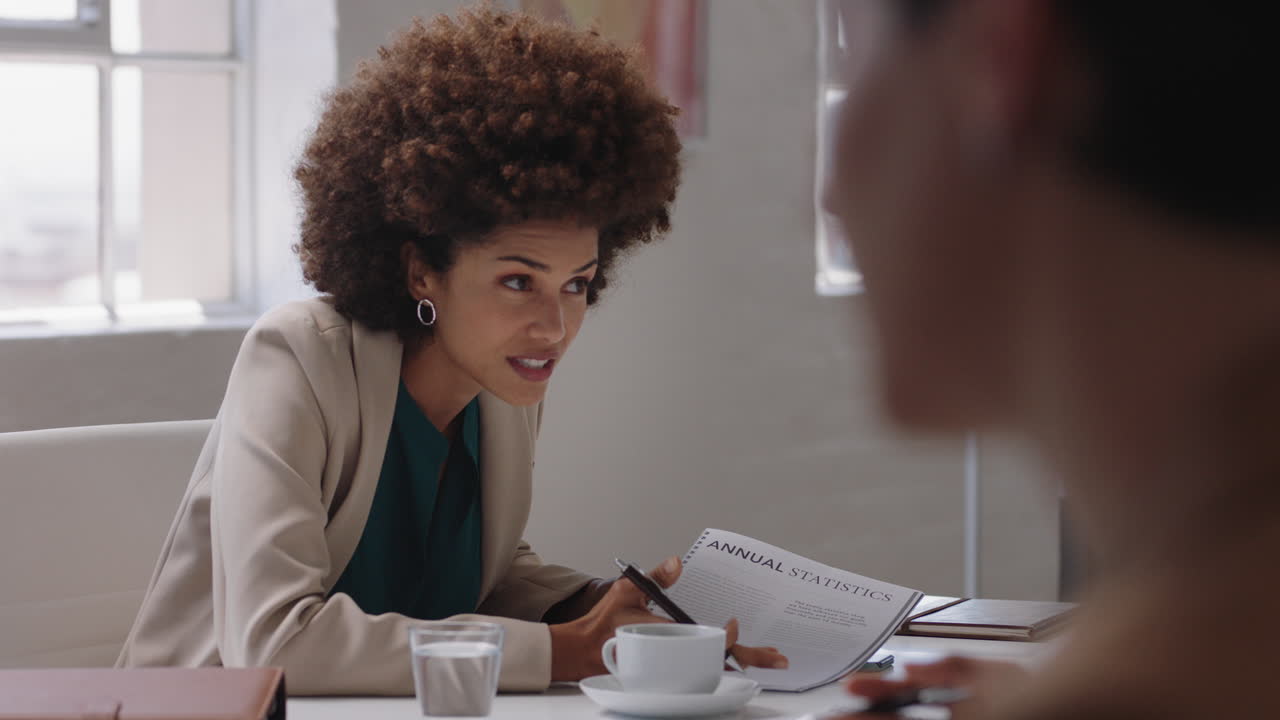 bellissima donna d'affari di razza mista capogruppo riunione con i colleghi condivisione di idee creative per il progetto aziendale discussione della strategia aziendale in ufficio sala riunioni
