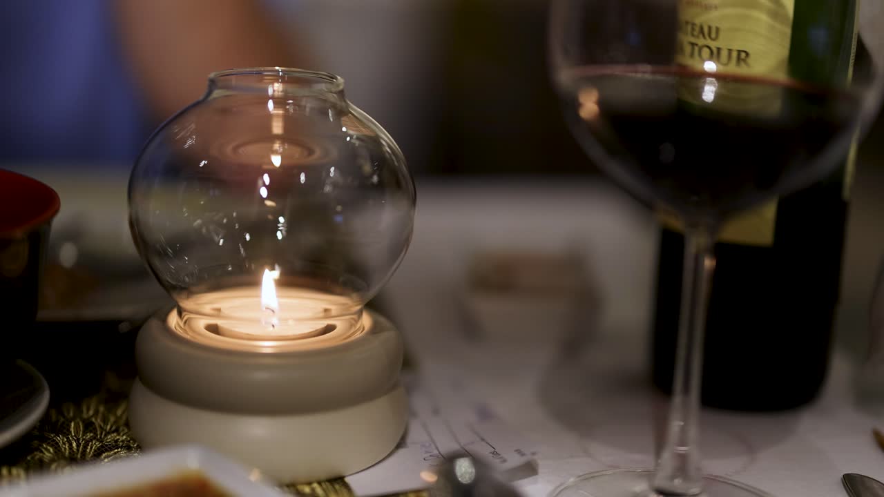 Intimate setting with candle and wine bottle