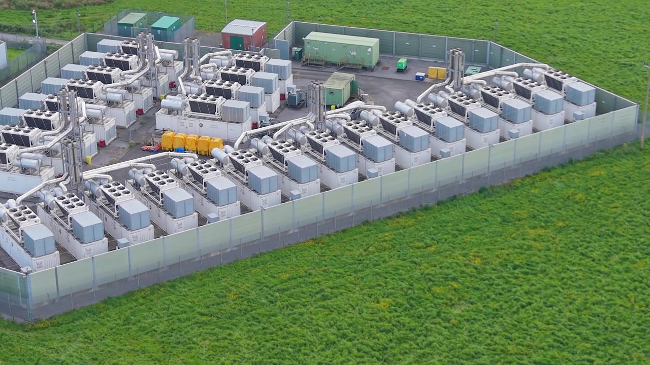 Close-up Drone View of Modern Gas Peaking Plant with exhaust stacks, generators, cooling systems. Provides rapid-response electricity to the grid during peak demand. Energy infrastructure. UK.