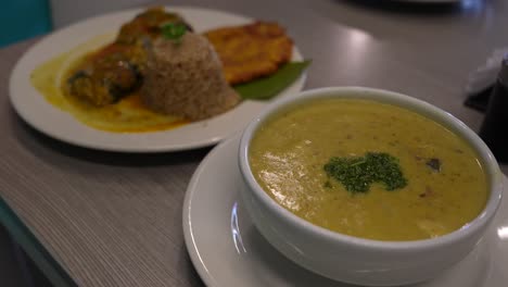 colombian fish sancocho soup served with catfish, coconut rice and fried plantain