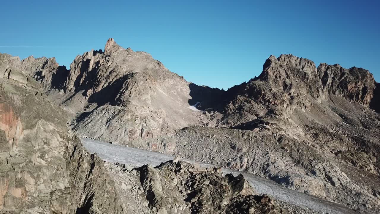 picos de montaña rocosos en los alpes suizos, glaciar y cielo azul, vista aérea de drones