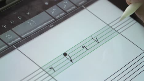 Artist-meticulously-crafting-musical-compositions-on-a-digital-tablet