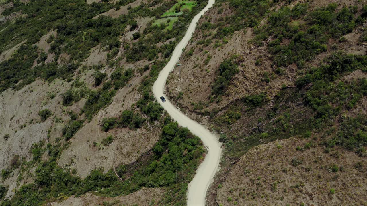 Soray car driving windy dirt road dust Laguna Lake Humantay Sulcantay Trek Peru Perú aerial drone clouds blue skies high altitude elevation Peruvian Andes Mountain Range peaks forward follow pan down